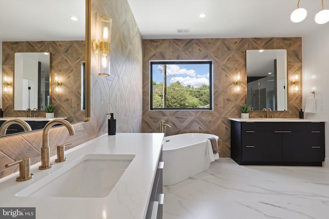 bathroom with a soaking tub, two vanities, marble finish floor, and a sink