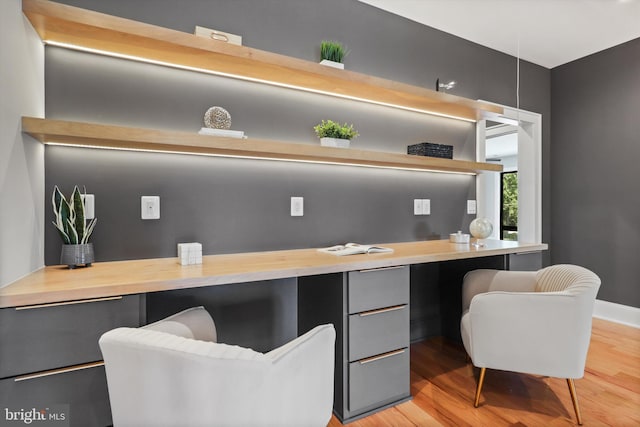 office area featuring light wood-type flooring and baseboards