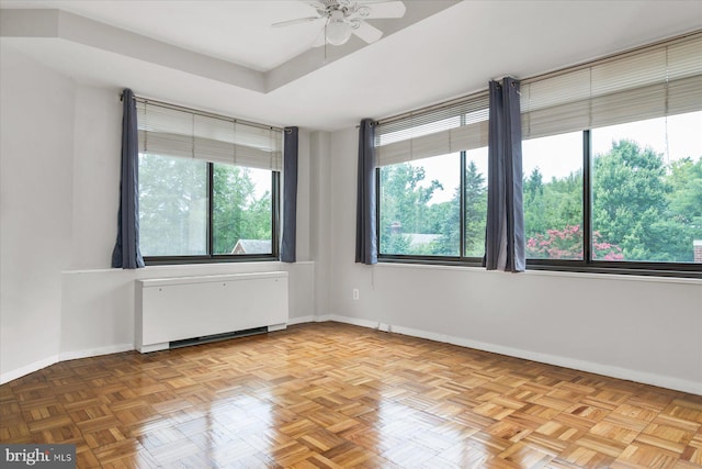 unfurnished room featuring ceiling fan, radiator heating unit, and light parquet flooring