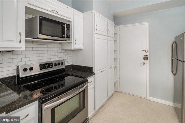 kitchen with white cabinetry, backsplash, appliances with stainless steel finishes, and dark stone counters