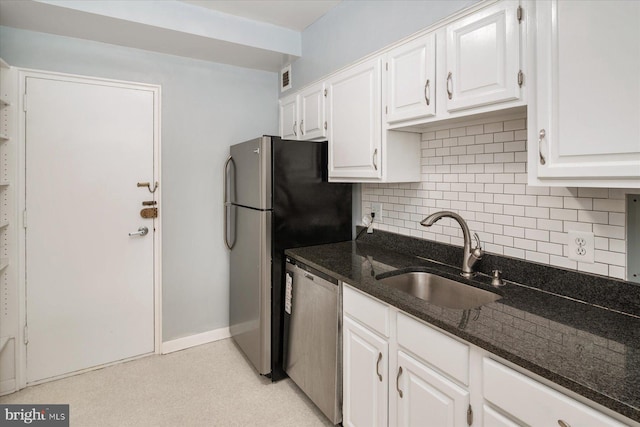 kitchen with decorative backsplash, dark stone counters, stainless steel appliances, sink, and white cabinets