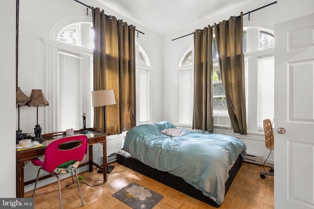 bedroom featuring parquet flooring, a baseboard radiator, and multiple windows