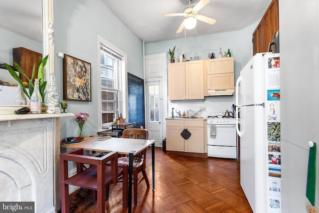 kitchen featuring a ceiling fan, white appliances, light countertops, and under cabinet range hood