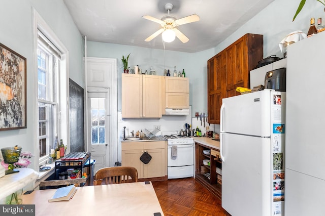 kitchen featuring under cabinet range hood, white appliances, a sink, a ceiling fan, and light countertops