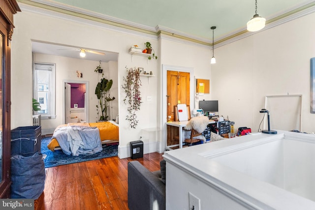 home office featuring hardwood / wood-style flooring, ceiling fan, ornamental molding, and baseboards