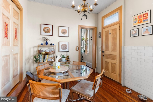 dining space featuring wood finished floors and a notable chandelier