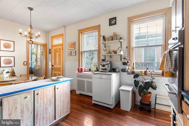 kitchen with dark wood-style floors, white dishwasher, tile walls, and a wealth of natural light