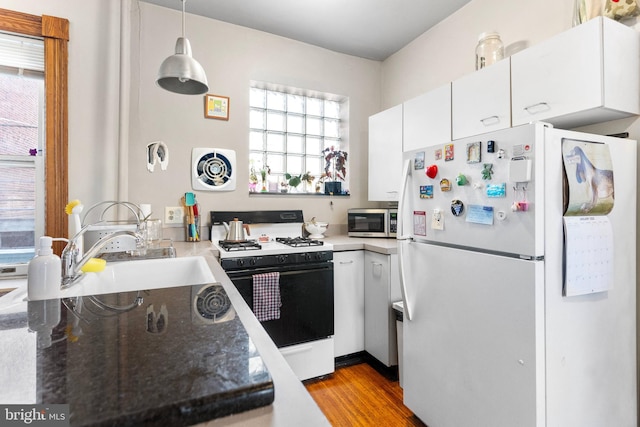 kitchen with visible vents, white cabinets, stainless steel microwave, freestanding refrigerator, and gas range oven