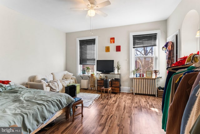 bedroom featuring radiator, ceiling fan, and wood finished floors