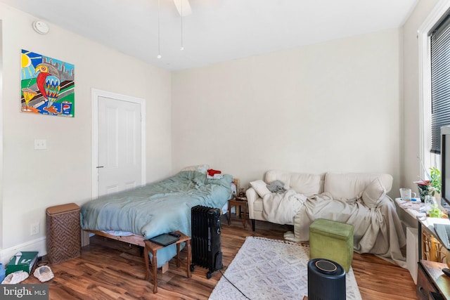 bedroom featuring multiple windows, ceiling fan, and wood finished floors