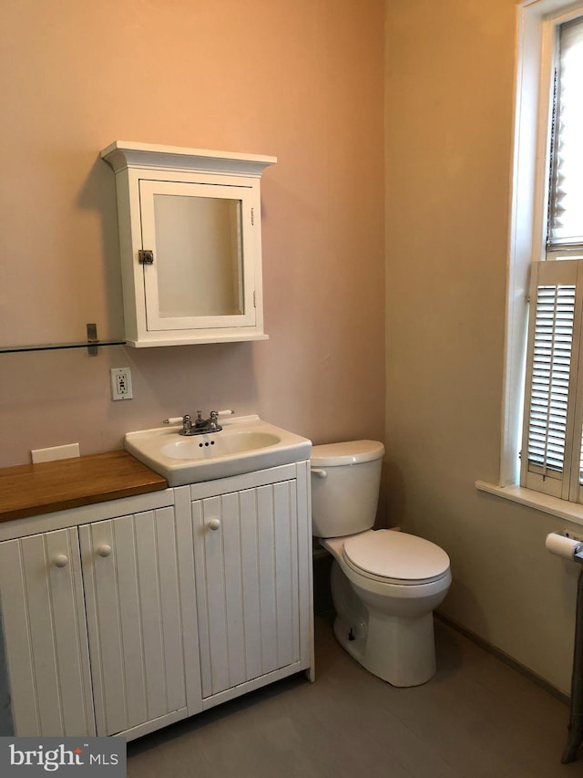 half bathroom featuring vanity and toilet