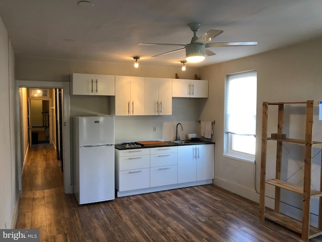 kitchen featuring ceiling fan, dark wood finished floors, freestanding refrigerator, and white cabinetry