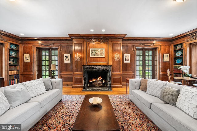 living area with light wood-type flooring, french doors, and a healthy amount of sunlight