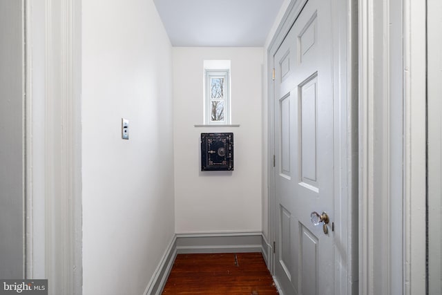 hall with dark wood-type flooring and baseboards