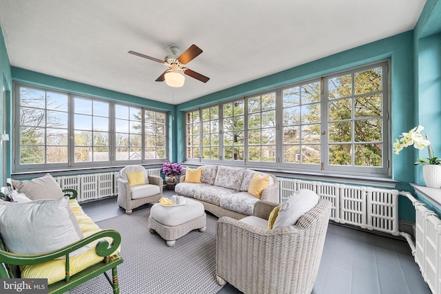 sunroom with an outdoor living space, radiator heating unit, and a ceiling fan