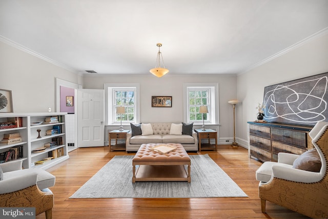living area featuring light wood finished floors, visible vents, and crown molding