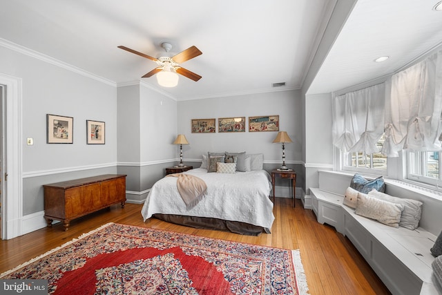 bedroom with crown molding, ceiling fan, light wood finished floors, and baseboards