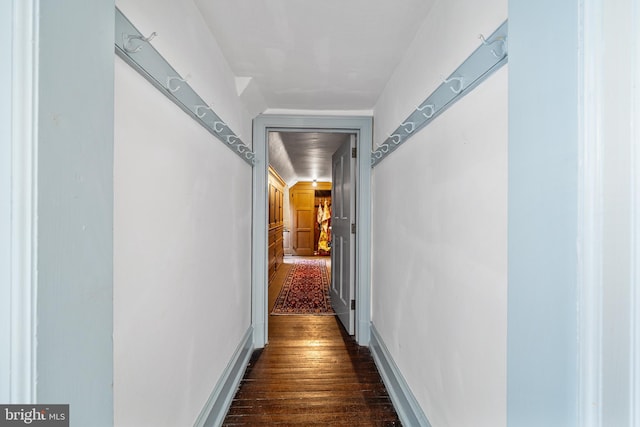 corridor with baseboards and dark wood finished floors