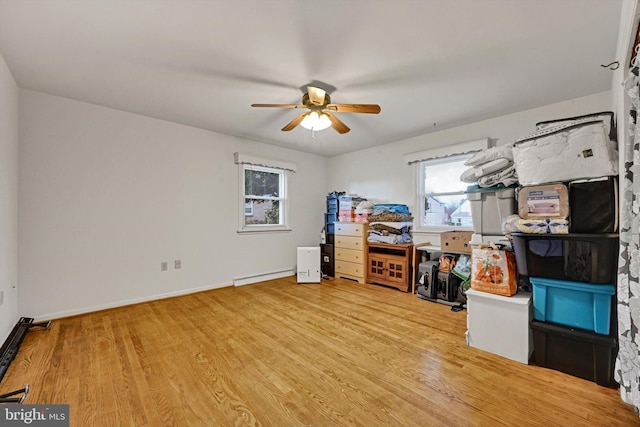 interior space with hardwood / wood-style floors, ceiling fan, and a baseboard radiator