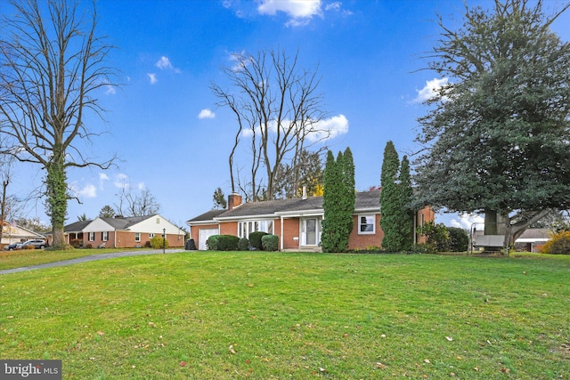 ranch-style house with a garage and a front lawn