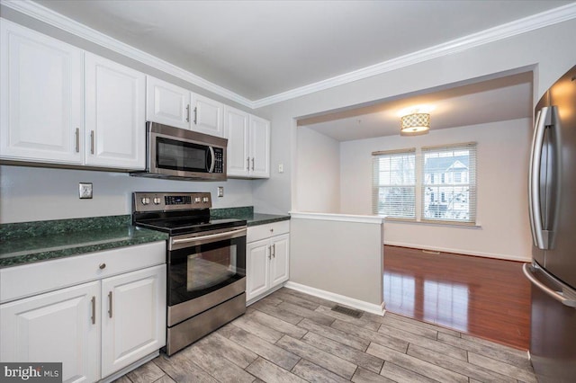 kitchen featuring white cabinets, stainless steel appliances, light hardwood / wood-style flooring, and ornamental molding