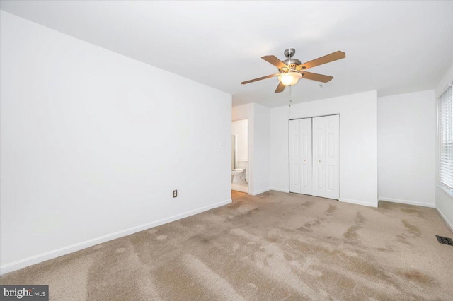 unfurnished bedroom featuring light carpet, a closet, and ceiling fan