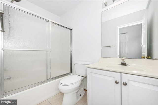 full bathroom featuring shower / bath combination with glass door, vanity, toilet, and tile patterned flooring