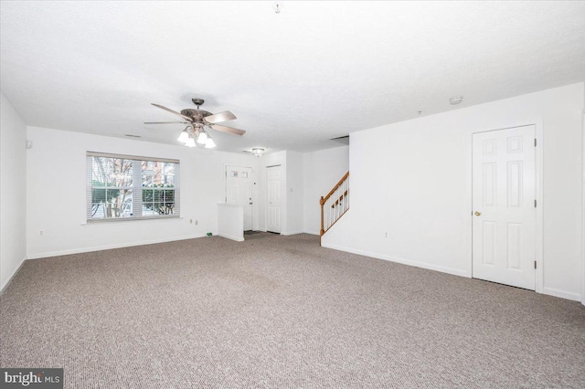 unfurnished living room featuring carpet flooring, ceiling fan, and a textured ceiling