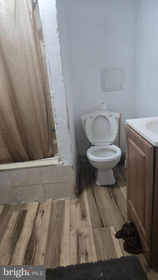 full bathroom featuring vanity, hardwood / wood-style floors, toilet, and shower / bath combo with shower curtain