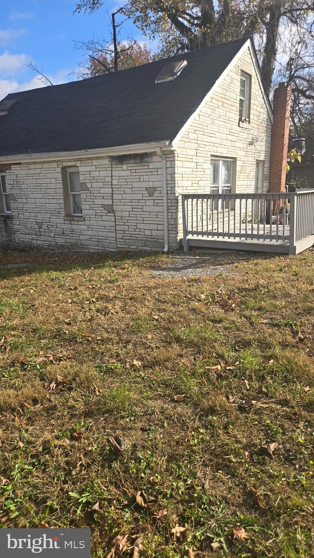 rear view of property with a yard and a deck