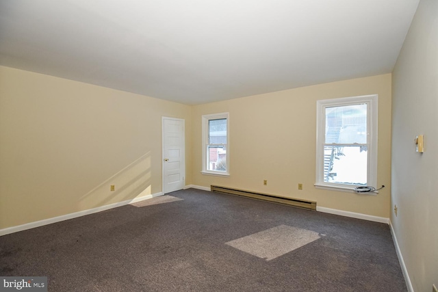 unfurnished room with baseboard heating and carpet