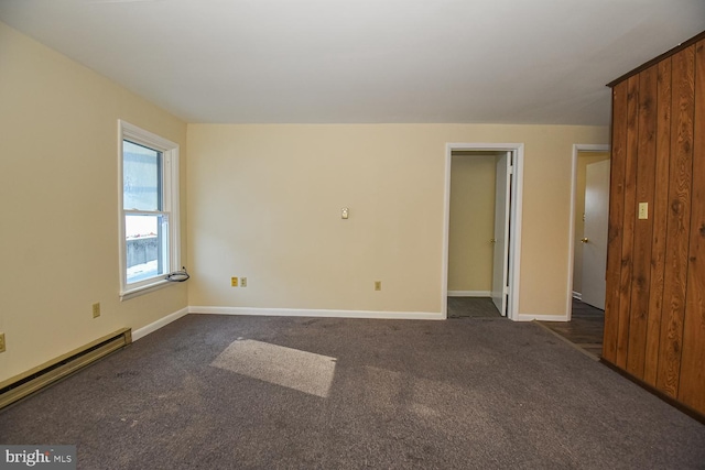 empty room with dark carpet and baseboard heating