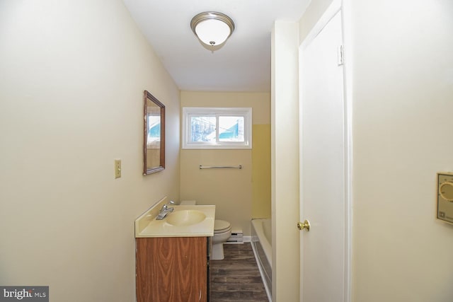 bathroom featuring wood-type flooring, vanity, toilet, and a baseboard heating unit