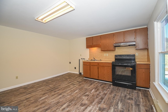 kitchen featuring a wealth of natural light, range hood, dark wood-type flooring, and black range with electric cooktop