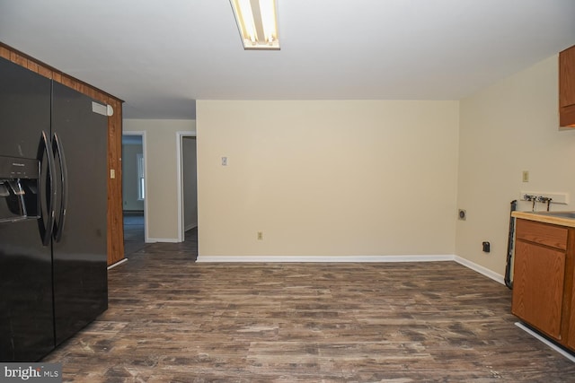 kitchen with black fridge and dark wood-type flooring