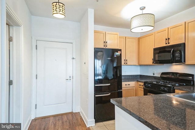 kitchen featuring light brown cabinets, kitchen peninsula, light hardwood / wood-style floors, decorative light fixtures, and black appliances