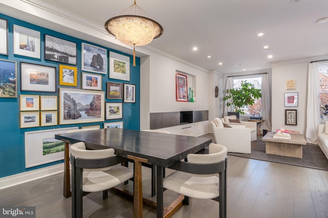 dining space with wood-type flooring and ornamental molding