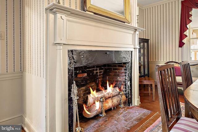 interior details with a fireplace, wood-type flooring, and ornamental molding