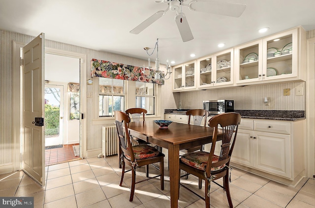 dining area with ceiling fan, light tile patterned floors, and radiator