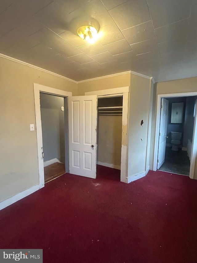 unfurnished bedroom featuring carpet flooring, a closet, and ornamental molding