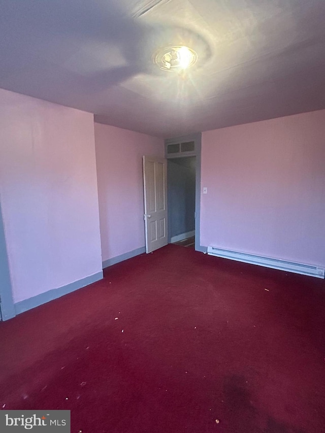 unfurnished room featuring a baseboard heating unit