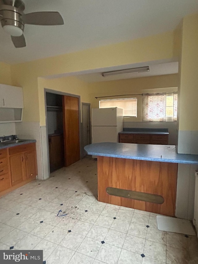 kitchen with kitchen peninsula, ceiling fan, and white refrigerator