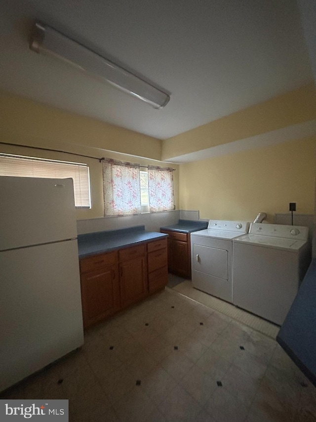 laundry area with washing machine and clothes dryer and cabinets