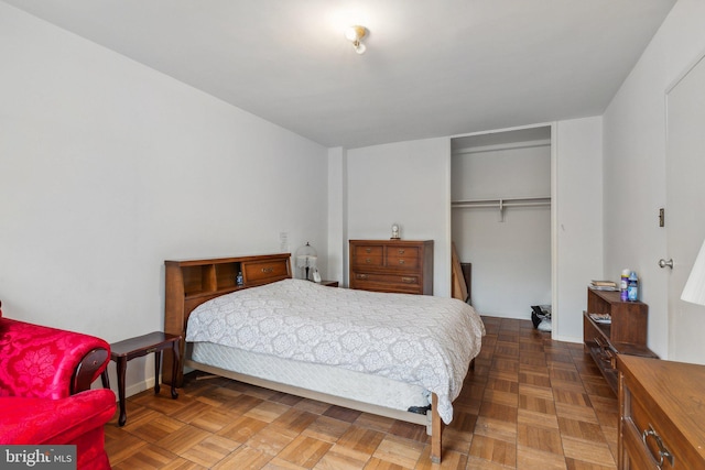 bedroom with a closet and dark parquet floors