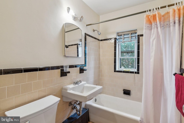 bathroom with toilet, tile walls, and shower / bath combo with shower curtain