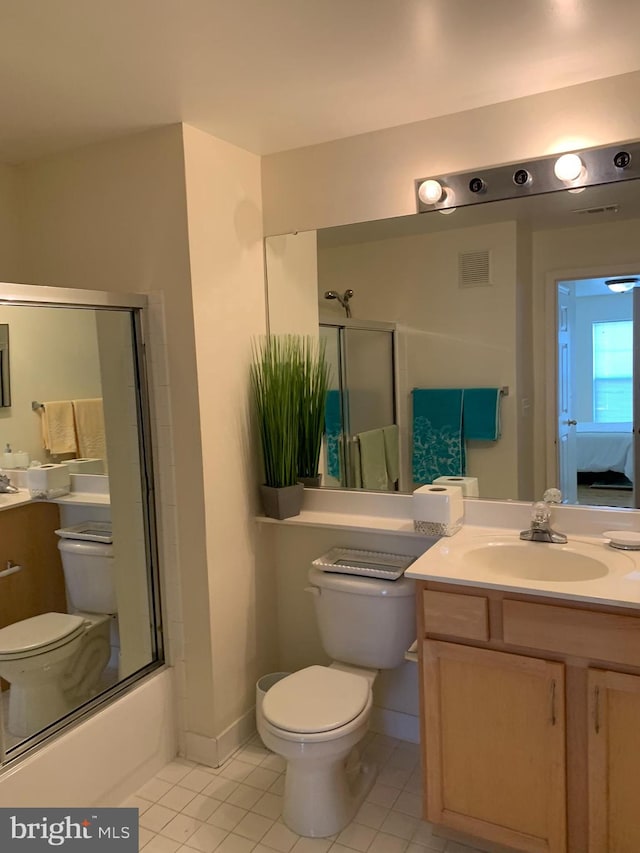 full bathroom featuring tile patterned floors, toilet, combined bath / shower with glass door, and vanity