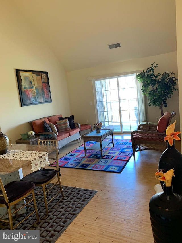 living room with wood-type flooring and vaulted ceiling