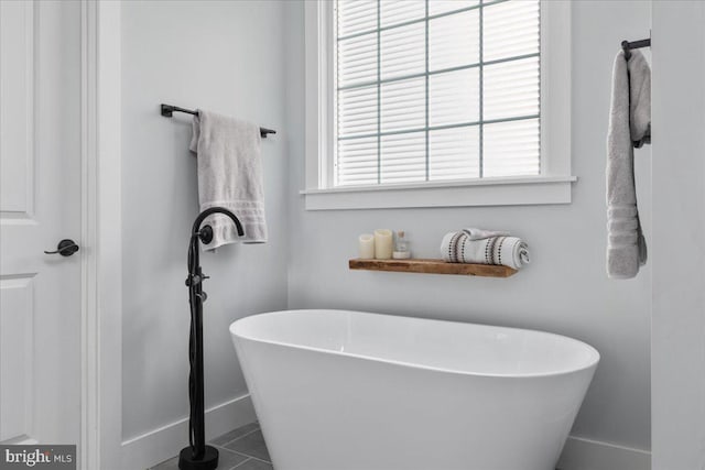 bathroom with tile patterned flooring and a bath