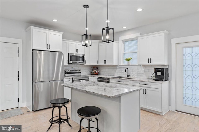 kitchen with appliances with stainless steel finishes, white cabinetry, and sink