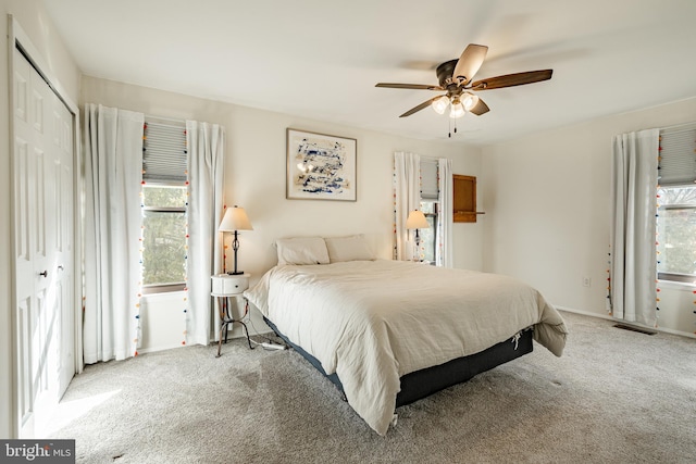 bedroom with ceiling fan, carpet, and a closet